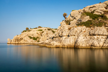 Fototapeta na wymiar Felsklippen mit Spiegelung in der glatten Wasseroberfläche des Mittelmeeres bei einer Aufnahme mit Langzeitbelichtung