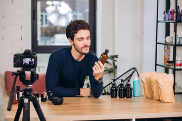 positive young man in stylish outfit sitting