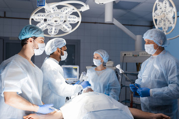 Stitching after a complex and bloody surgery. Modern medical equipment allow surgeons to perform delicate and accurate operations. Professional treatment concept