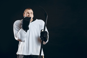 Frightened hockey goalkeeper holding gaming stick bites his hand in protective glove shocked with missed goal. Sport, human emotions concept.