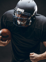 Handsome caucasian man wearing american football uniform and helmet running in action with a ball...