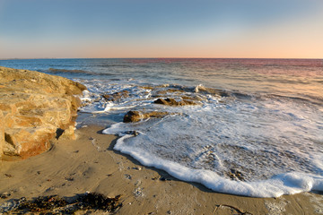 Coastline at sunset and foam of wave on a beach at Damgan, a commune in the Morbihan department of Brittany in north-western France.
