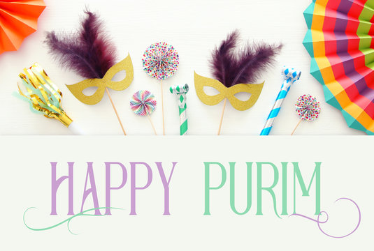 Purim celebration concept (jewish carnival holiday) over white wooden background. Top view.
