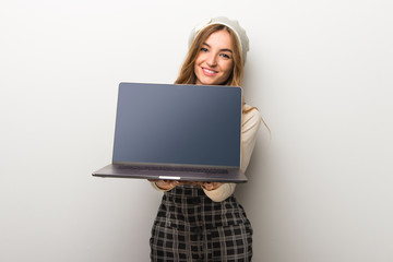 Fashionably woman wearing hat showing a laptop