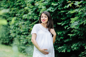 young happy pregnant woman relaxing and enjoying life in nature