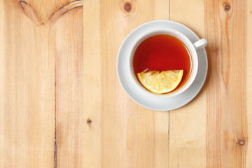 tea with lemon in white Cup on wooden surface background