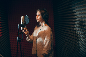 pretty woman in stylish outfit recording her firt hit. copy space. side view photo