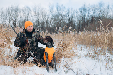 hunter and dog are in the winter forest. close up photo.copy space. holiday with friend.happy moments with a pet