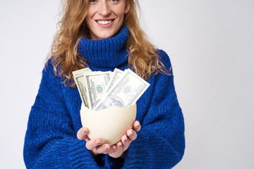 young woman with an egg and money in hand