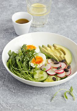 Healthy vegetable salad with avocado,egg and arugula. Plant based, clean eating, vegetarian concepts. 