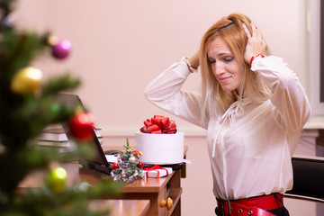 Tired woman working in an office at Christmas