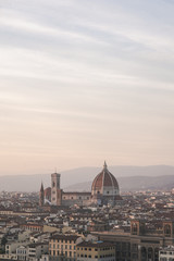 Fototapeta na wymiar Vertical photo landscape of the city of Florence, Italy on a long-focus lens, view from the viewpoint of the cathedral Cattedrale di Santa Maria del Fiore in the evening time of the sunset.