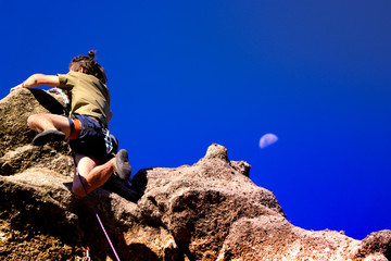 Climbing on the rock with the moon assuring