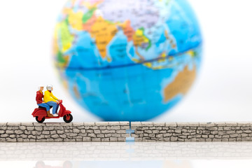 Miniature people : Tourist Drive a motorcycle along the wall, world map for background. Image use for security of data, network system concept.