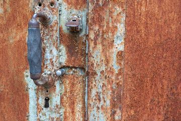 A close-up of an old rusty iron door