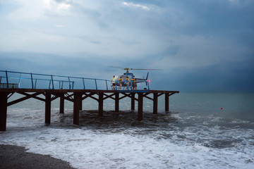 Coast guard is coming to a helicopter during a sea storm