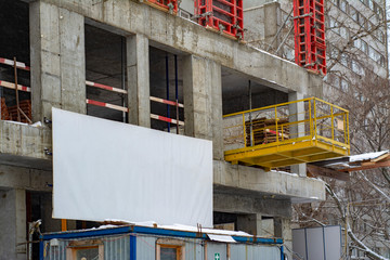 Construction site with a large empty white banner © Николай Батаев