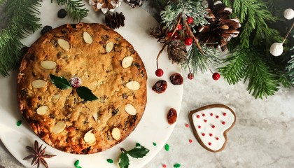 Obraz na płótnie Canvas Homemade Christmas fruitcake on festive Xmas holiday background