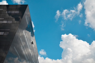 reflection on dark building blue sky and clouds