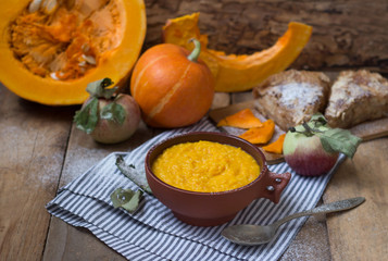 Pumpkin porridge in a clay bowl with pumpkin and apple