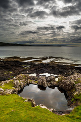 Fototapeta na wymiar Picturesque Coast With Small Grassy Ponds On The Isle Of Skye In Scotland