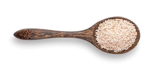brown rice in wood spoon isolated on white background. top view