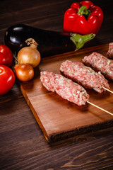 Raw hot dogs on cutting board and vegetables