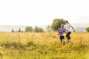 Boys running in the meadow, having fun