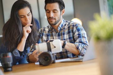 Photographer colleagues going through photos on camera