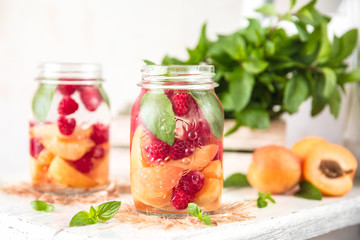 Fototapeta na wymiar Cold Fruit Infused Detox Water with apricots raspberries and mint