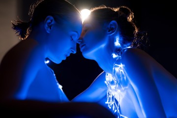 Nude women in bath in blue lights in the dark