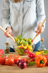 The girl prepares a vegetable salad. Vertical photo