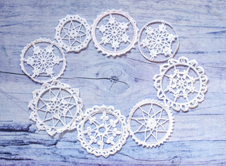 White hooked snowflakes on a gray wooden background. Inside the space for the text.