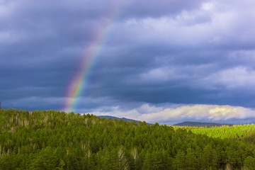 rainbow on gray sky background in mountans