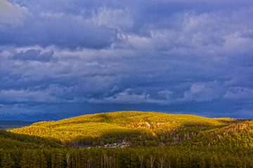 Fototapeta premium grey stormy clouds above the green mountain