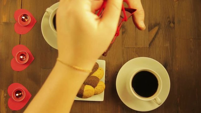 Young people in a cafe by candlelight give each other souvenirs.