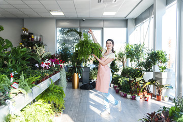 Smiling florist enjoy arranging plants © focusandblur