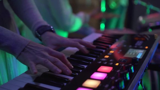 keyboard player playing synthesizer close-up