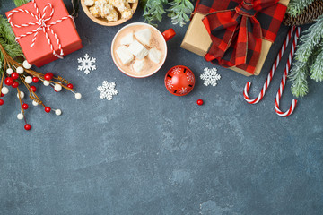 Christmas holiday background with gift boxes and hot chocolate cup on blackboard.