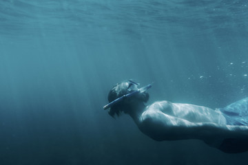 Freediver guy relaxing underwater.