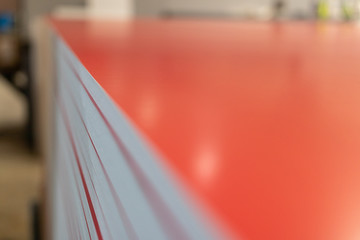 Professional material printing facility, big vinyl sheets, ready for large sound proofing projects. Glossy, matte, ecological architectural elements stacked and piled. White foam, red layers.
