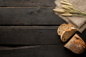 Wooden background with fresh bread and wheat