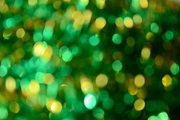 Bokeh. Holiday background. Christmas lights. Glitter. Defocused sparkles. New Year backdrop. Festive wallpaper. Blinks. Carnival. Tinsel. Bokeh retro style photo. Green.