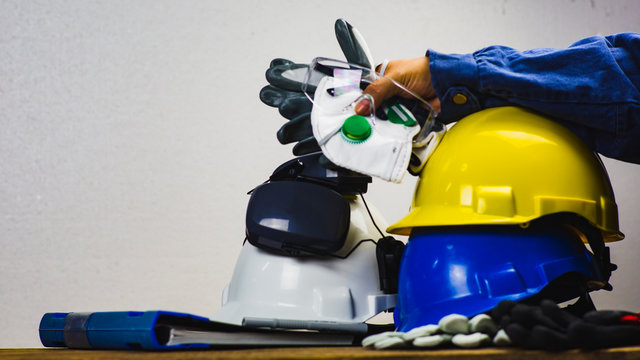 Works safety concept: PPE (Personal Protective Equipment), hard hat or industrial helmet for protection the worker from accident during working at construction site, factory or industry building.