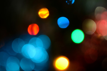 Bokeh. Christmas tree lights. Holiday background. Garland. Glitter. Christmas eve. Defocused sparkles. New Year backdrop. Blinks. Carnival. Bokeh retro style photo.