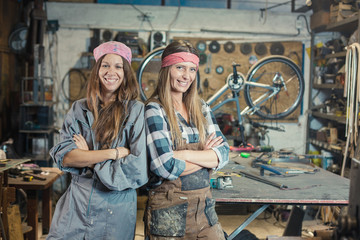 two young women in a workshop posing