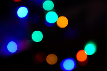 Bokeh. Christmas tree lights. Holiday background. Garland. Glitter. Christmas eve. Defocused sparkles. New Year backdrop. Blinks. Carnival. Bokeh retro style photo.