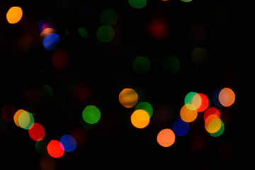 Bokeh. Christmas tree lights. Holiday background. Garland. Glitter. Christmas eve. Defocused sparkles. New Year backdrop. Blinks. Carnival. Bokeh retro style photo.