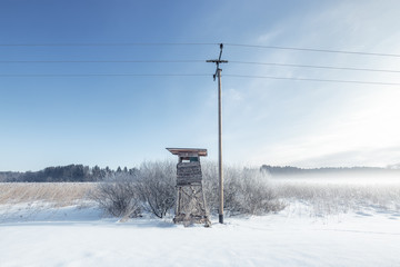 Hochsitz und Strommast in einer Moorlandschaft bei Münsing am Starnberger See, Bayern, Deutschland.