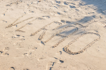 written in the sand of the beach, summer in portuguese